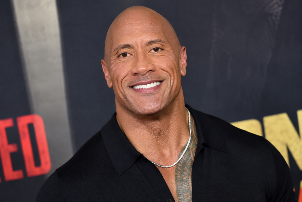 Dwayne Johnson smiling at a red-carpet premiere